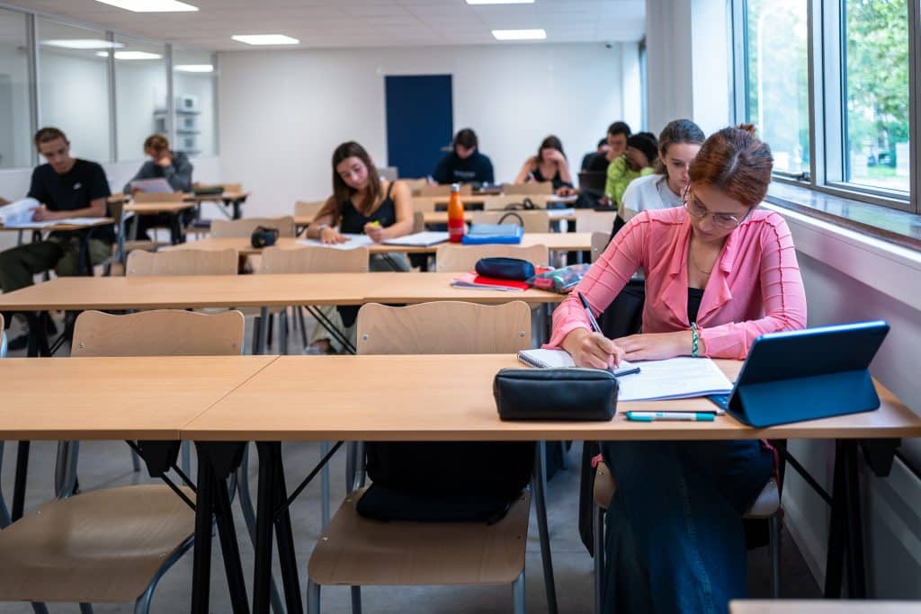 Étudiants en prépa médecine à Paris concentrés sur leurs révisions dans une salle de classe moderne.